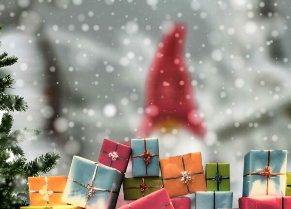 Weihnachtswichtel mit Geschenken und Tannebäumen im Schnee